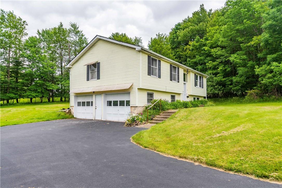 View of property exterior with a garage and a yard