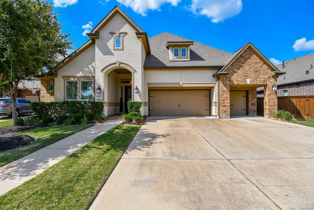 a front view of a house with yard and parking