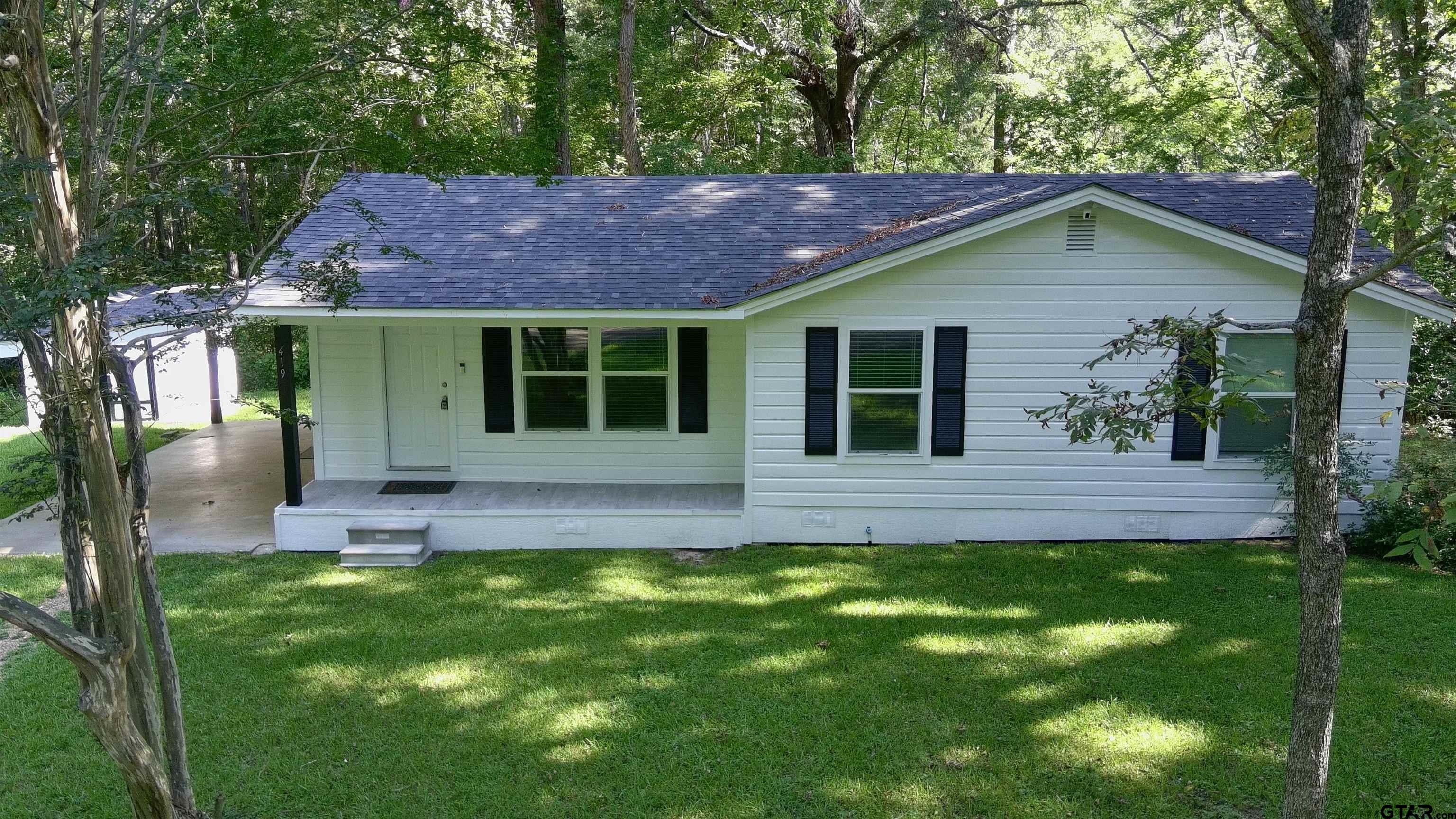 a view of house with backyard and outdoor seating