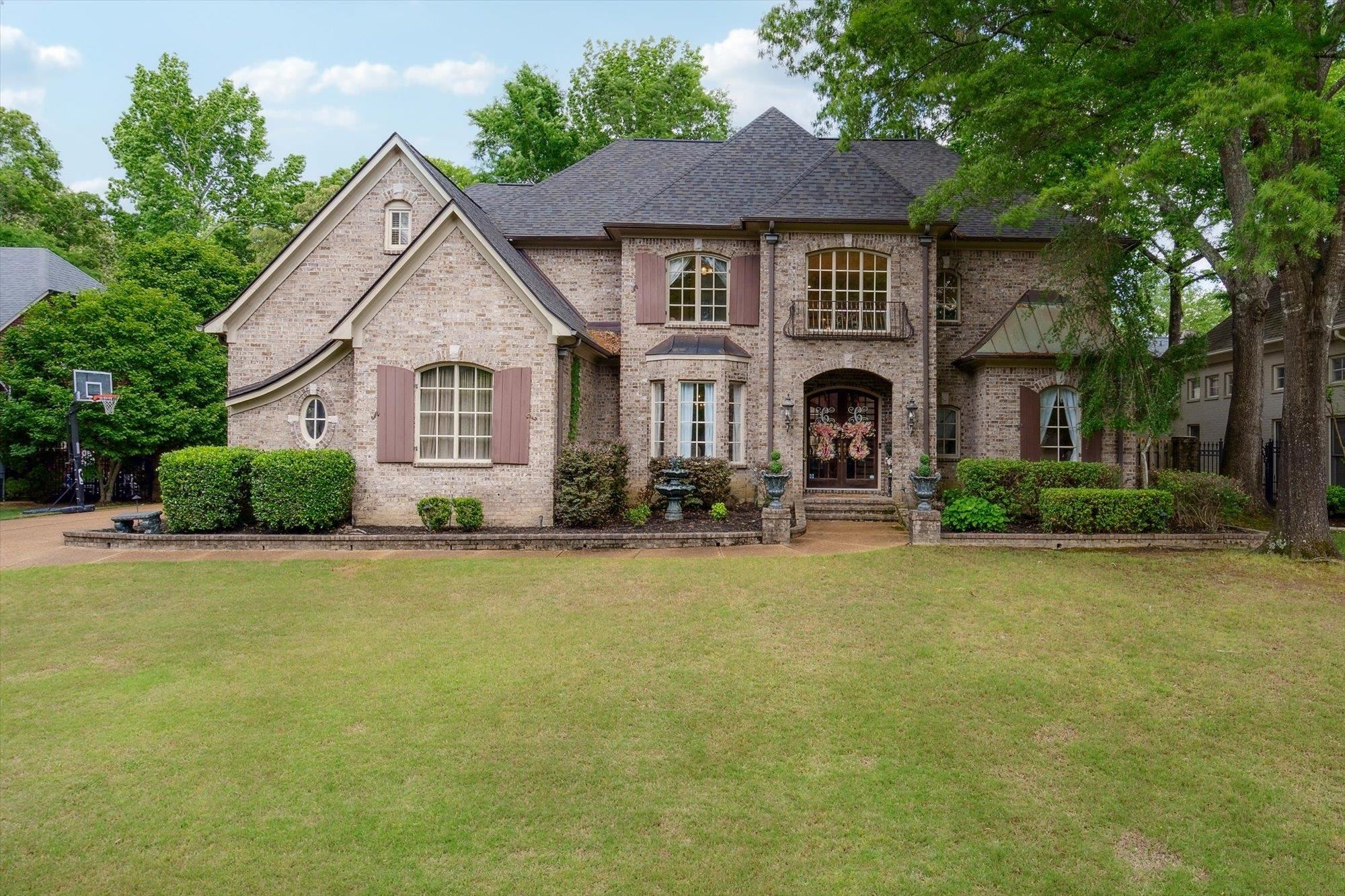 a front view of a house with yard and trees