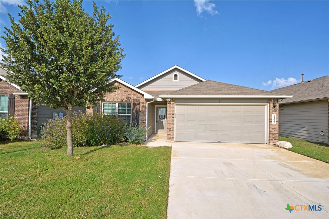 a front view of a house with a yard and garage