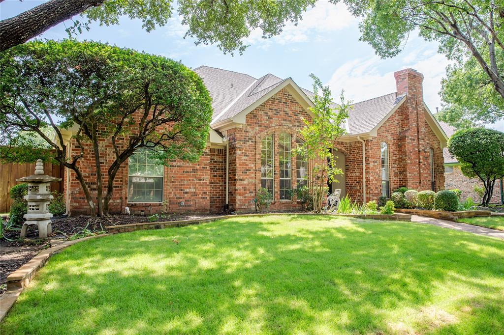 a view of a house with a big yard and large trees