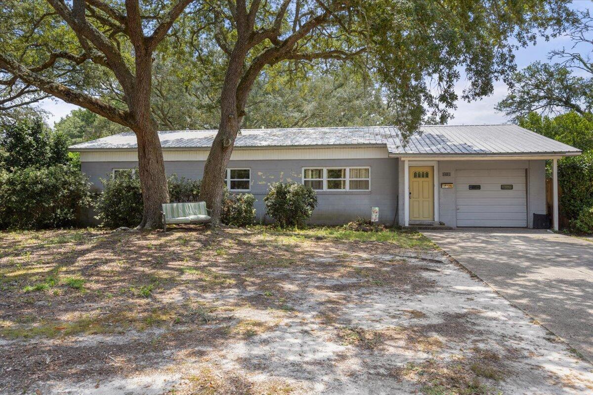 a view of a house with a yard and large tree