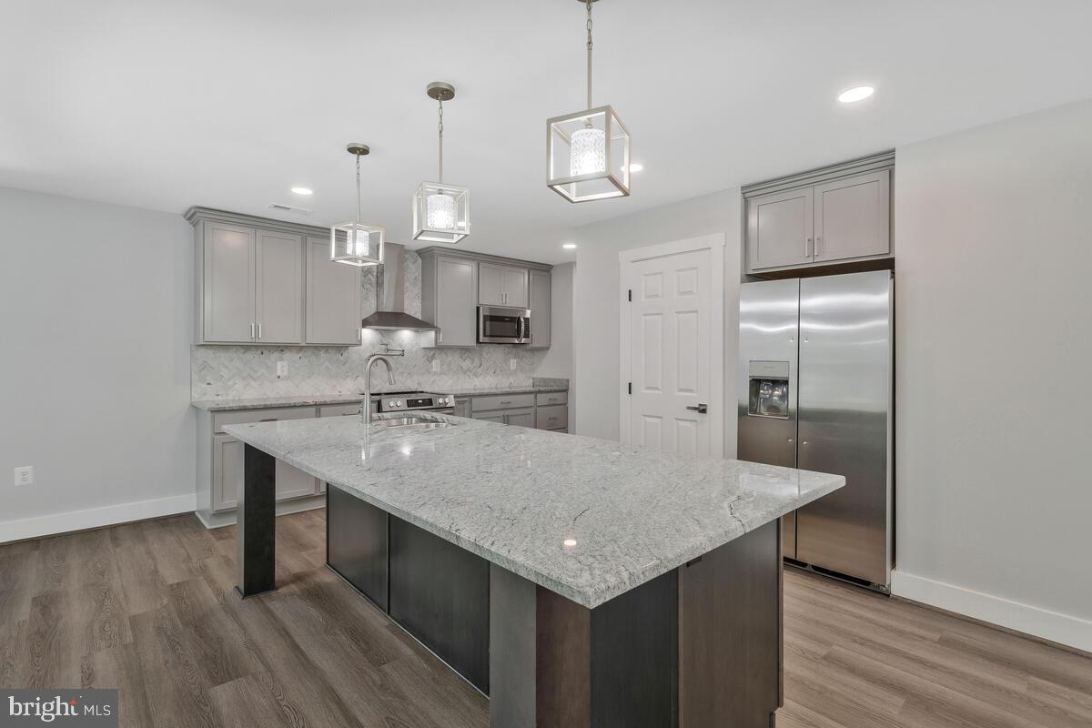 a kitchen with granite countertop a sink cabinets and wooden floor