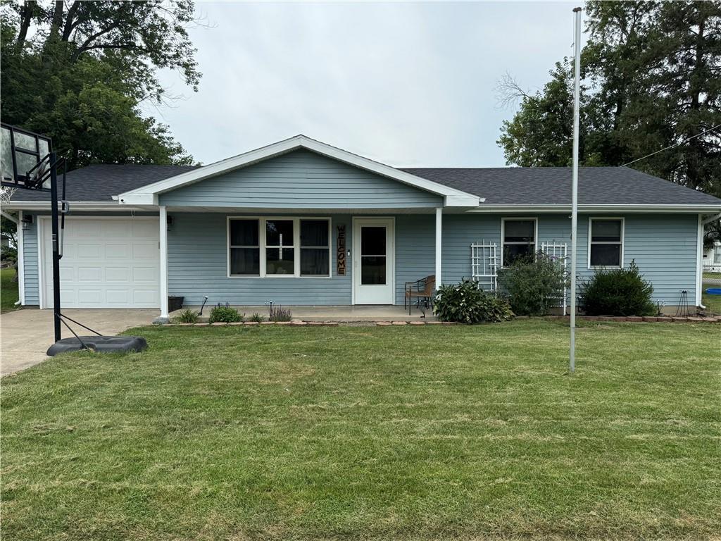 a house is sitting in middle of the grass