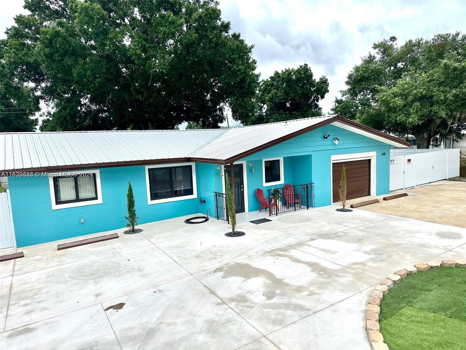 a view of a house with backyard and trees