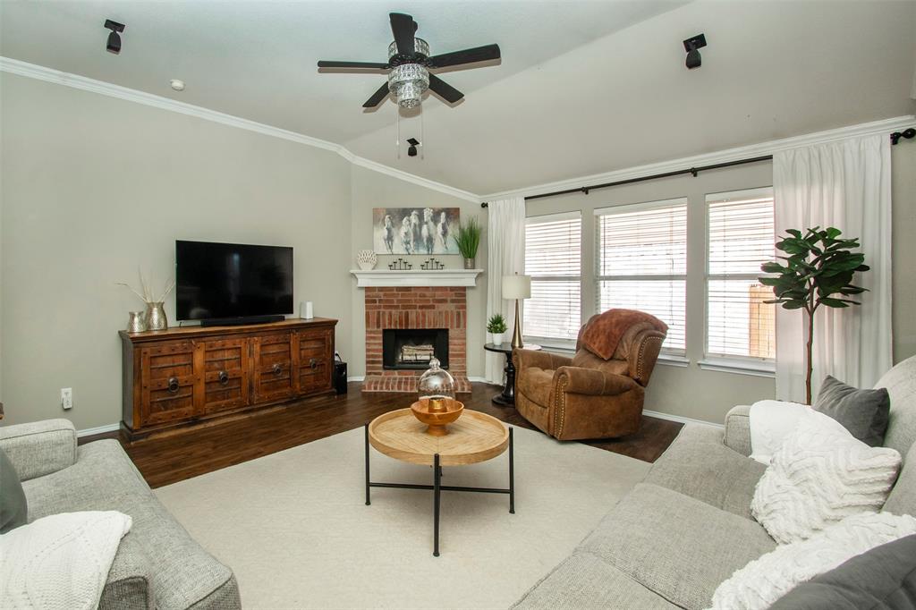 a living room with furniture a flat screen tv and a fireplace