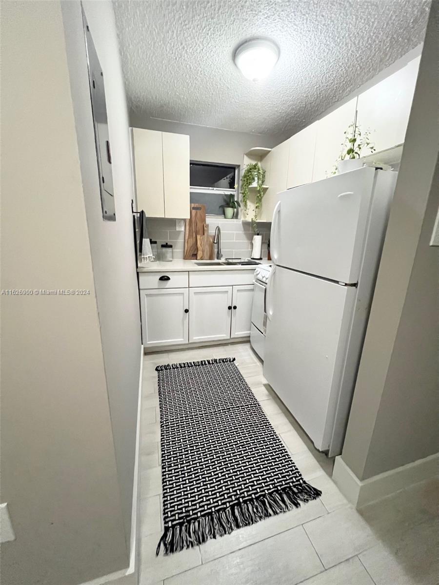 a white refrigerator freezer sitting inside of a kitchen