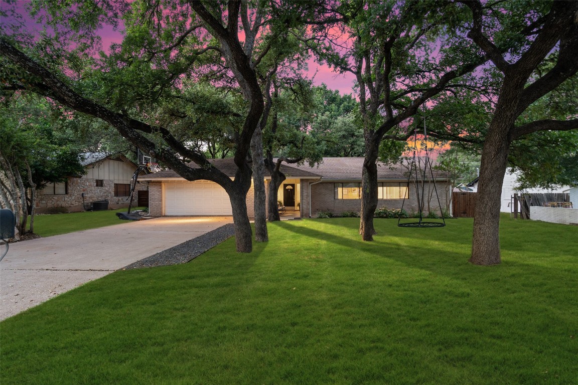 a front view of a house with a yard and tree