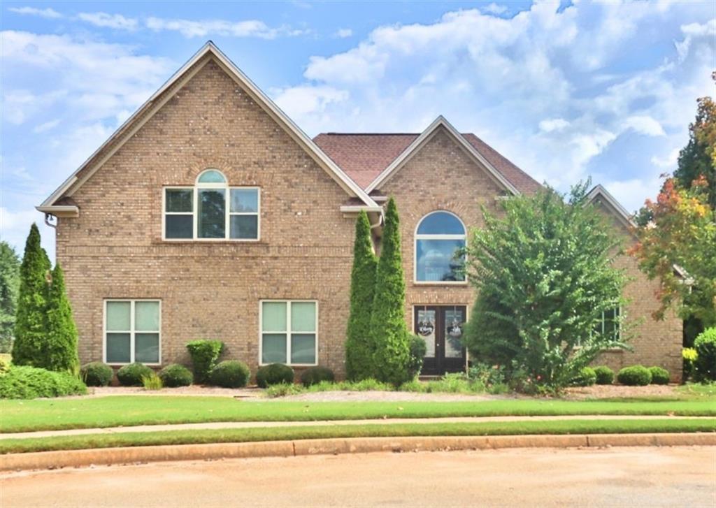 a view of a brick house next to a yard