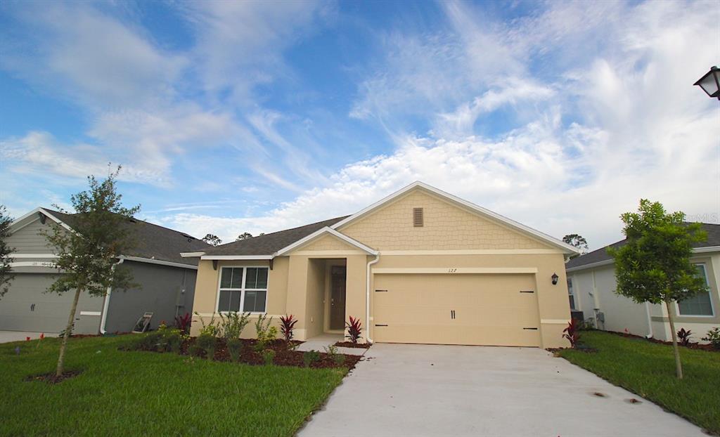 a front view of a house with a yard and a garage