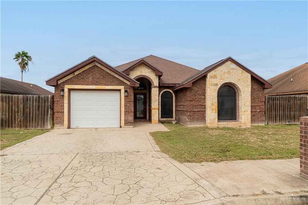 Ranch-style home with a garage and a front lawn