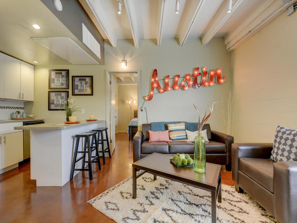 a living room with furniture and a wooden floor