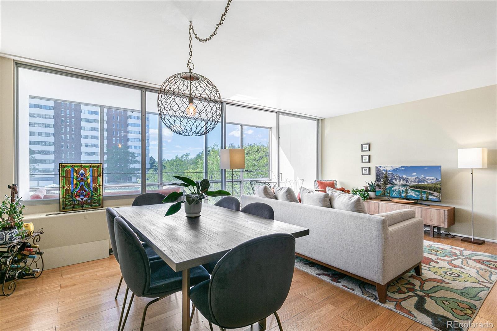 a living room with furniture a chandelier and a large window