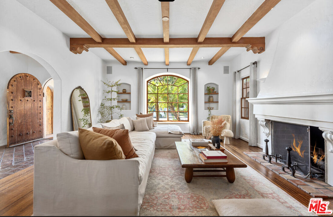 a living room with furniture fireplace and a large window