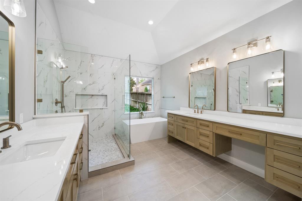 a large white bathroom with a large mirror vanity sink and bathtub