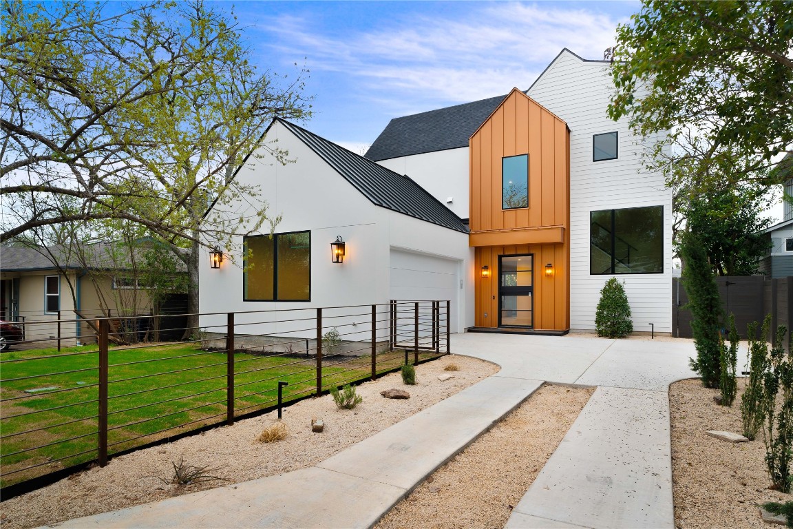 a view of a house with a yard and large tree