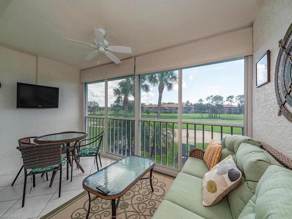 a living room with furniture tv and a floor to ceiling window