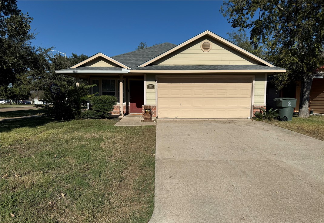 View of front facade with a garage and a front law