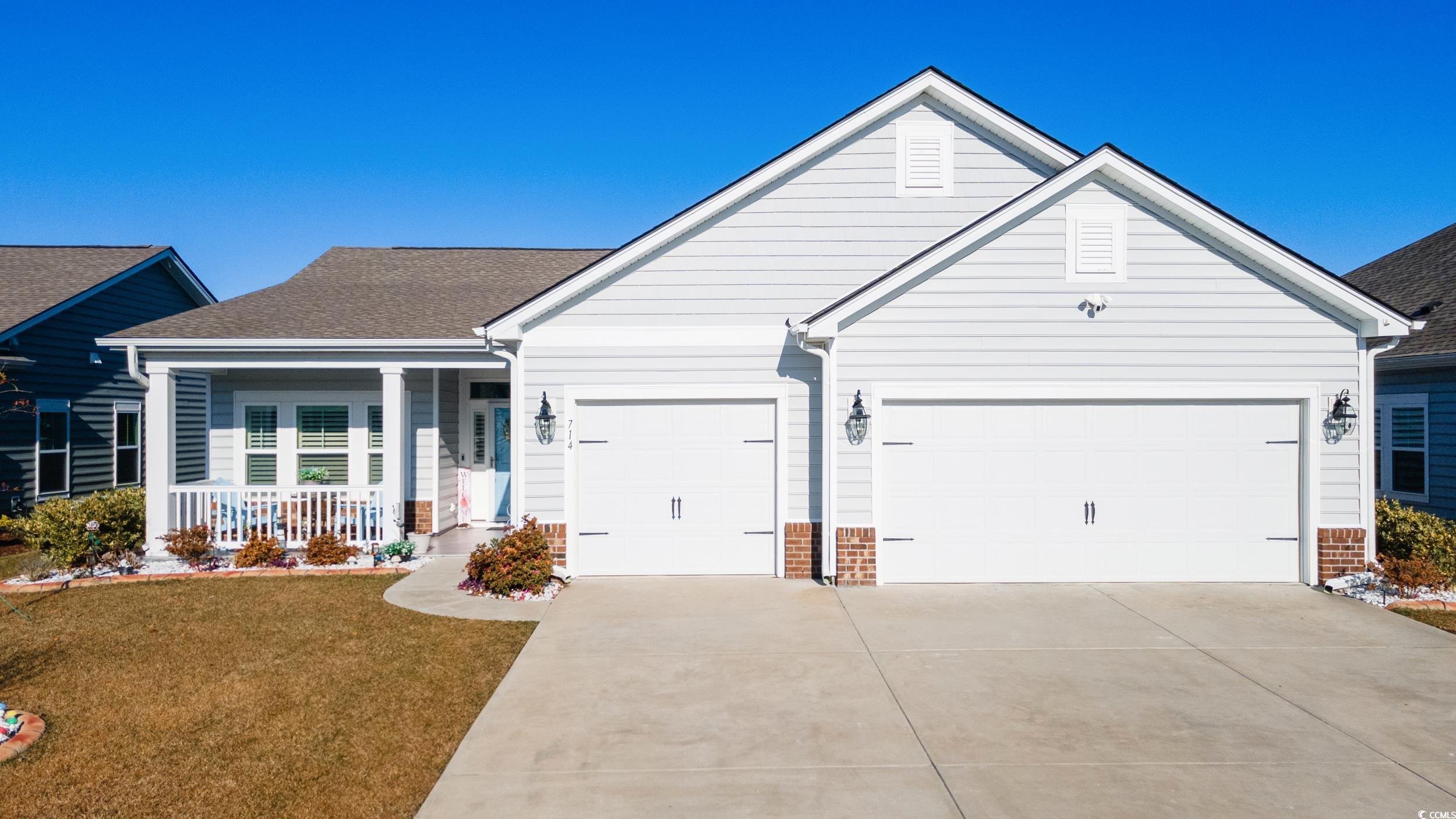 Ranch-style house featuring a front lawn, covered