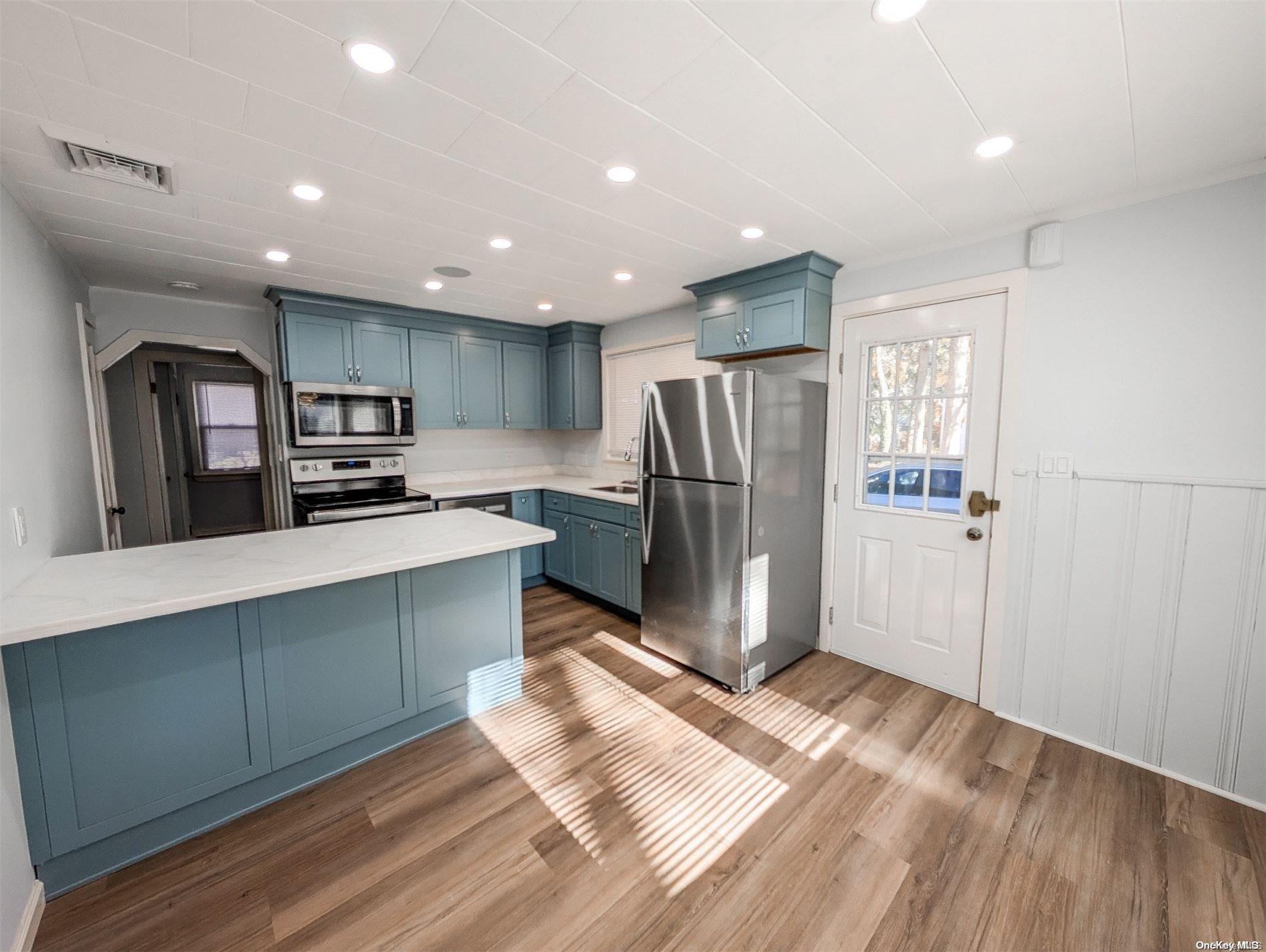 a kitchen with stainless steel appliances a refrigerator and a stove top oven