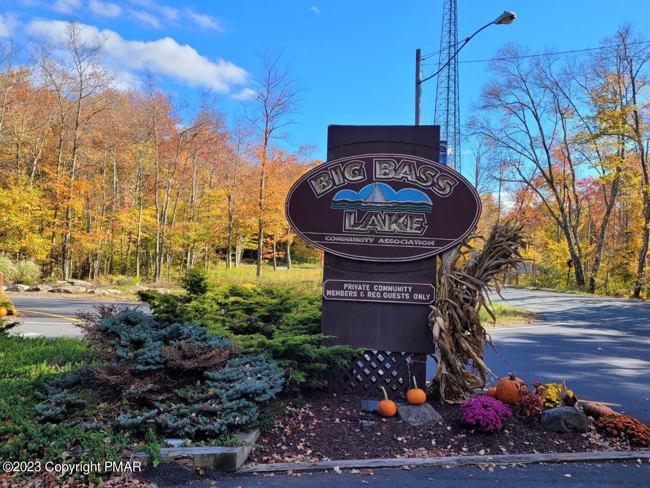 a sign board with a fire pit and some trees