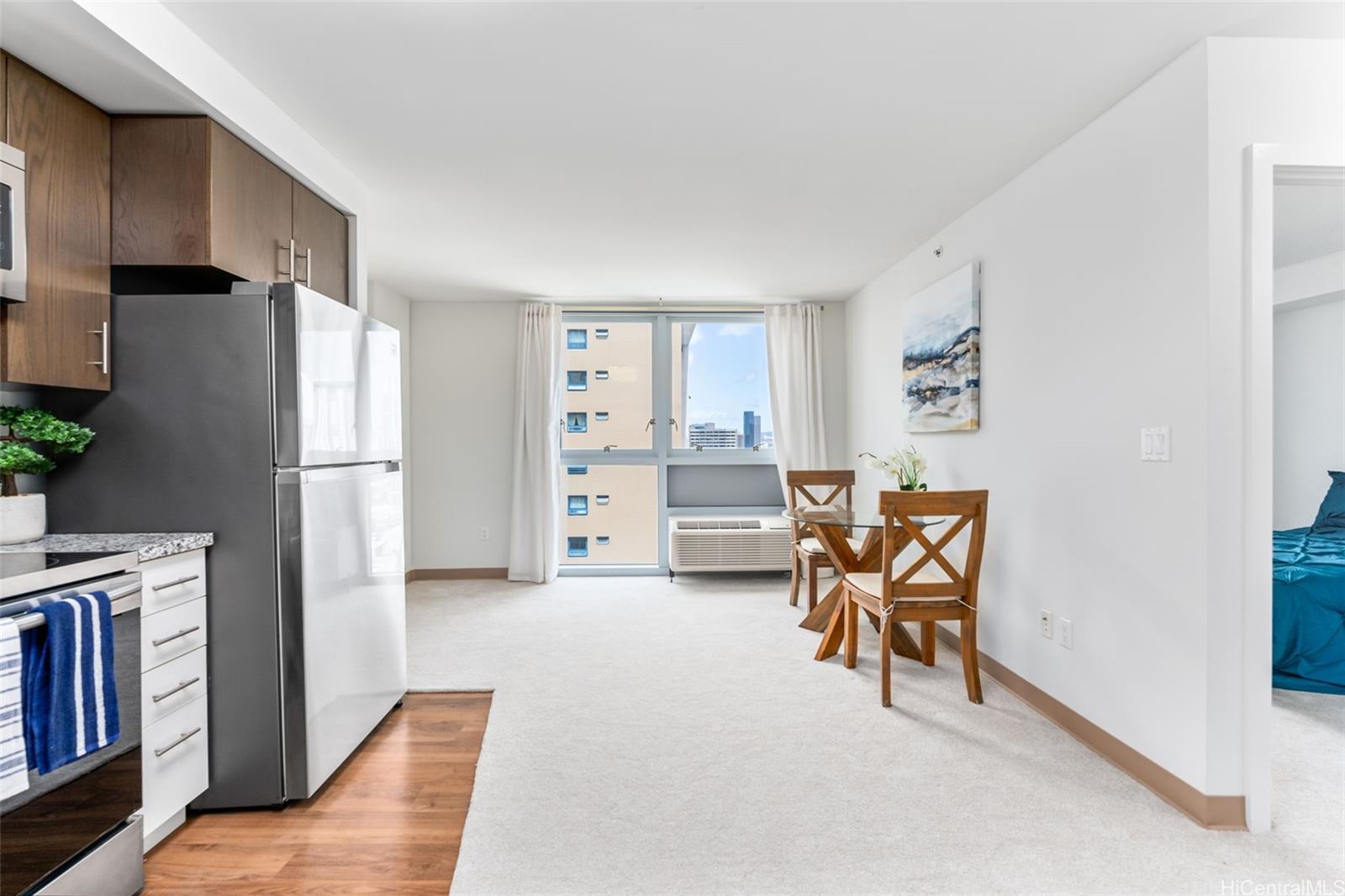 a view of a livingroom with furniture and a refrigerator