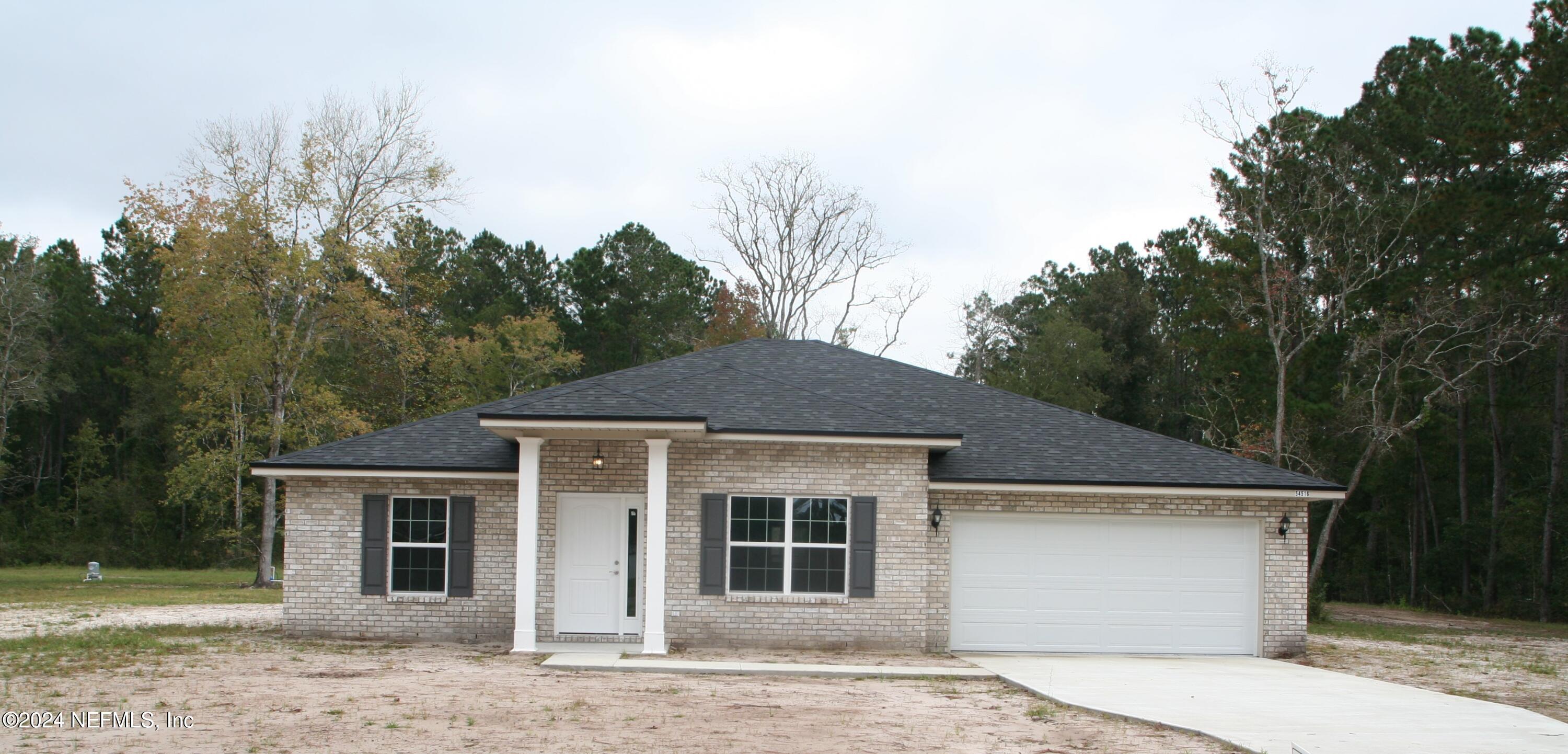 a front view of a house with a garden and yard