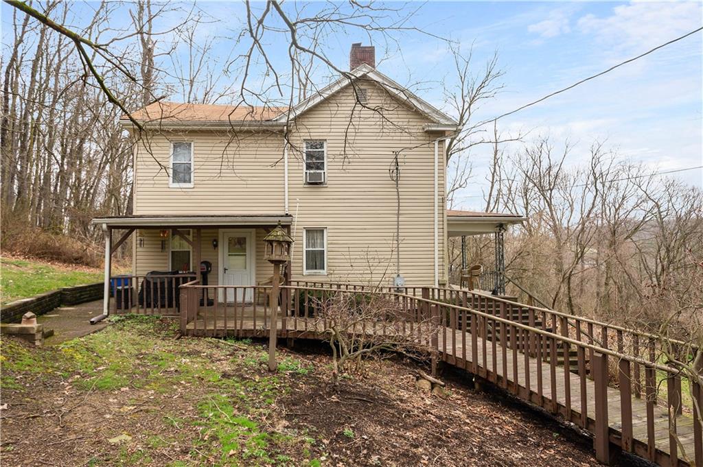 a view of a house with wooden fence and a bench