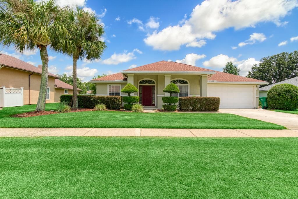 a front view of a house with a yard and potted plants