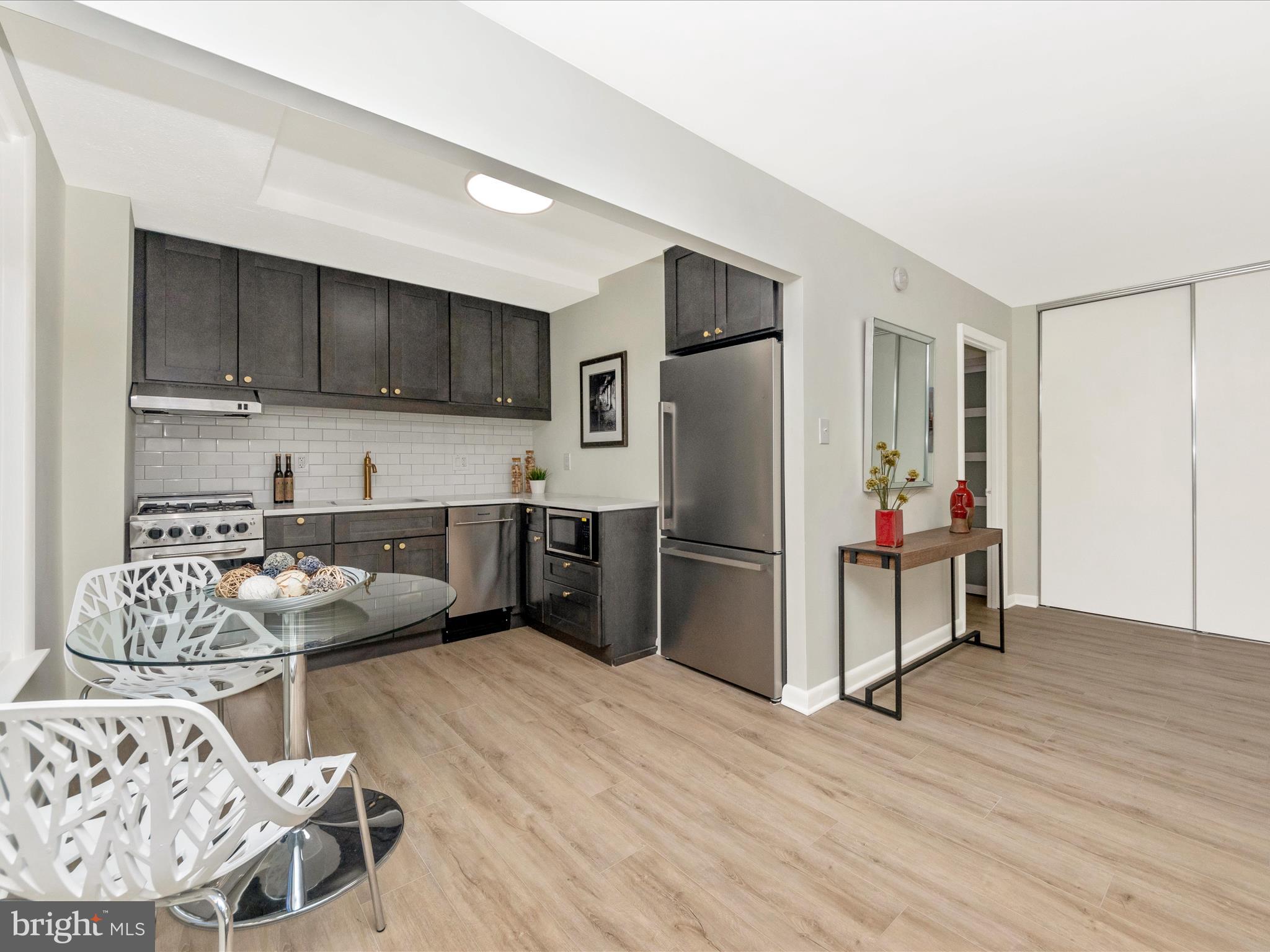 a kitchen with stainless steel appliances kitchen island granite countertop a refrigerator and a sink