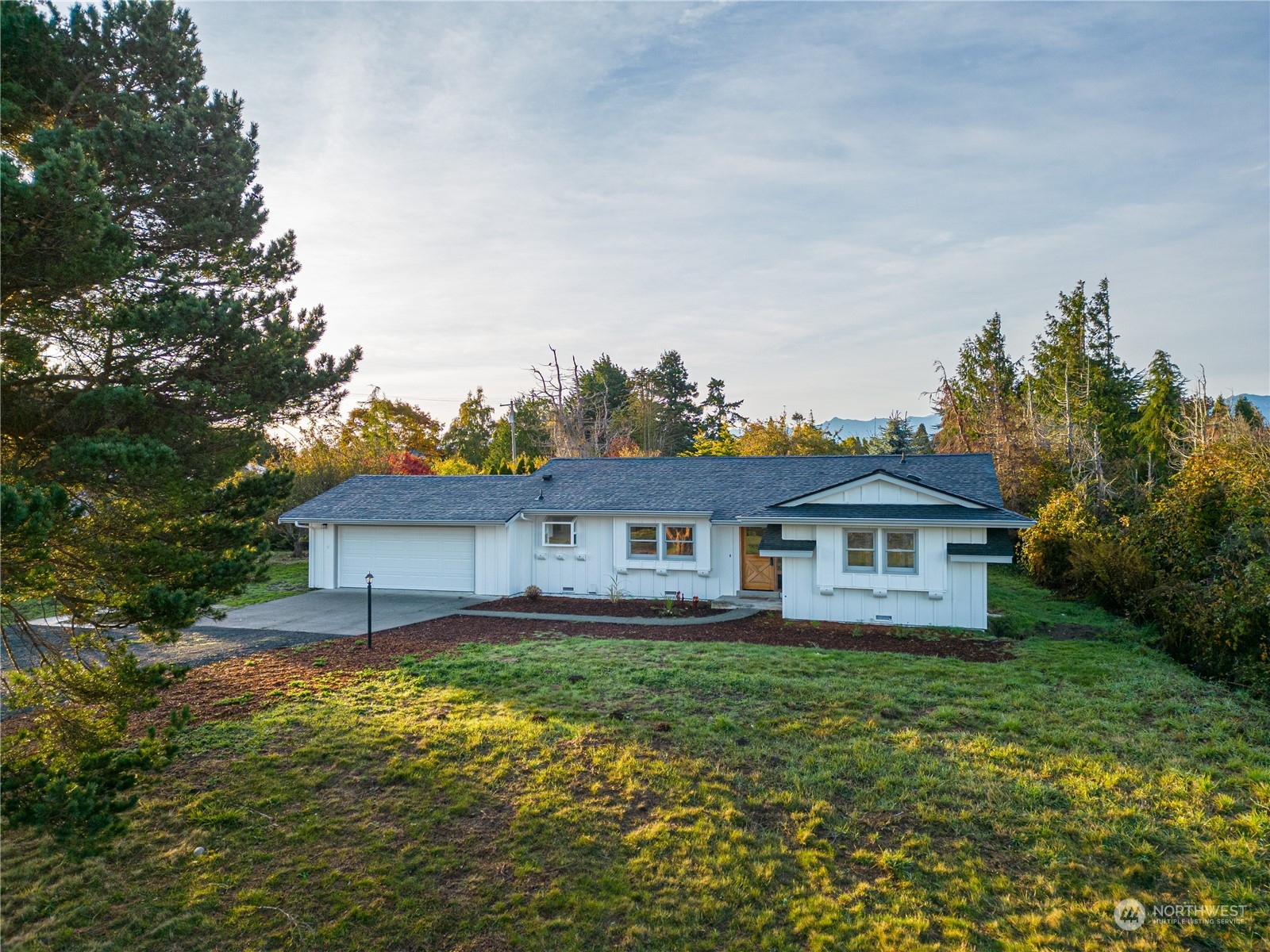 a front view of a house with a yard and lake view