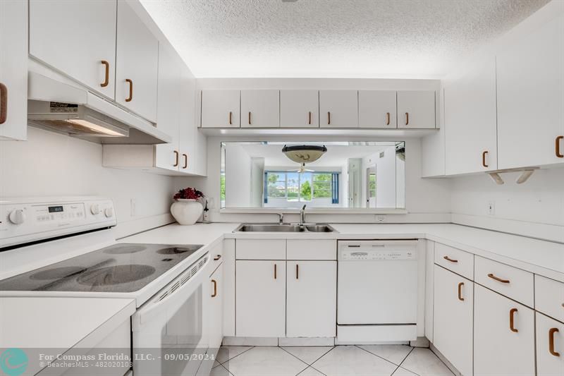 a kitchen with white cabinets stainless steel appliances and sink