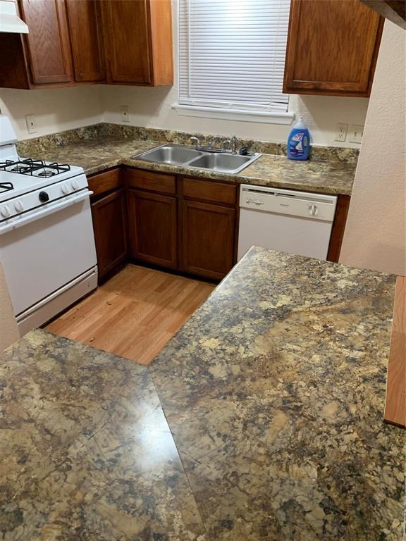 a kitchen with granite countertop a sink stove and cabinets