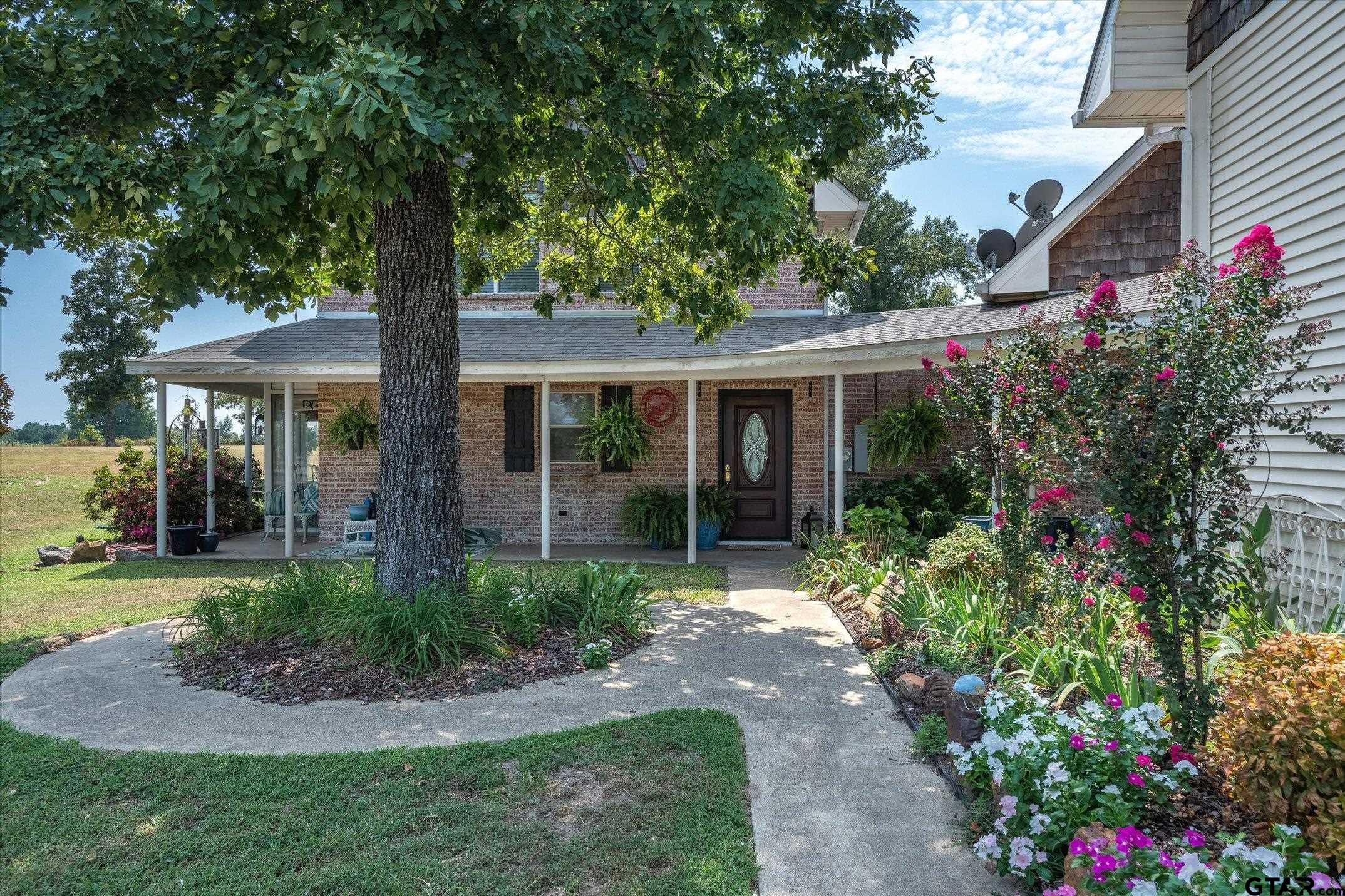 a front view of a house with a yard and fountain in middle