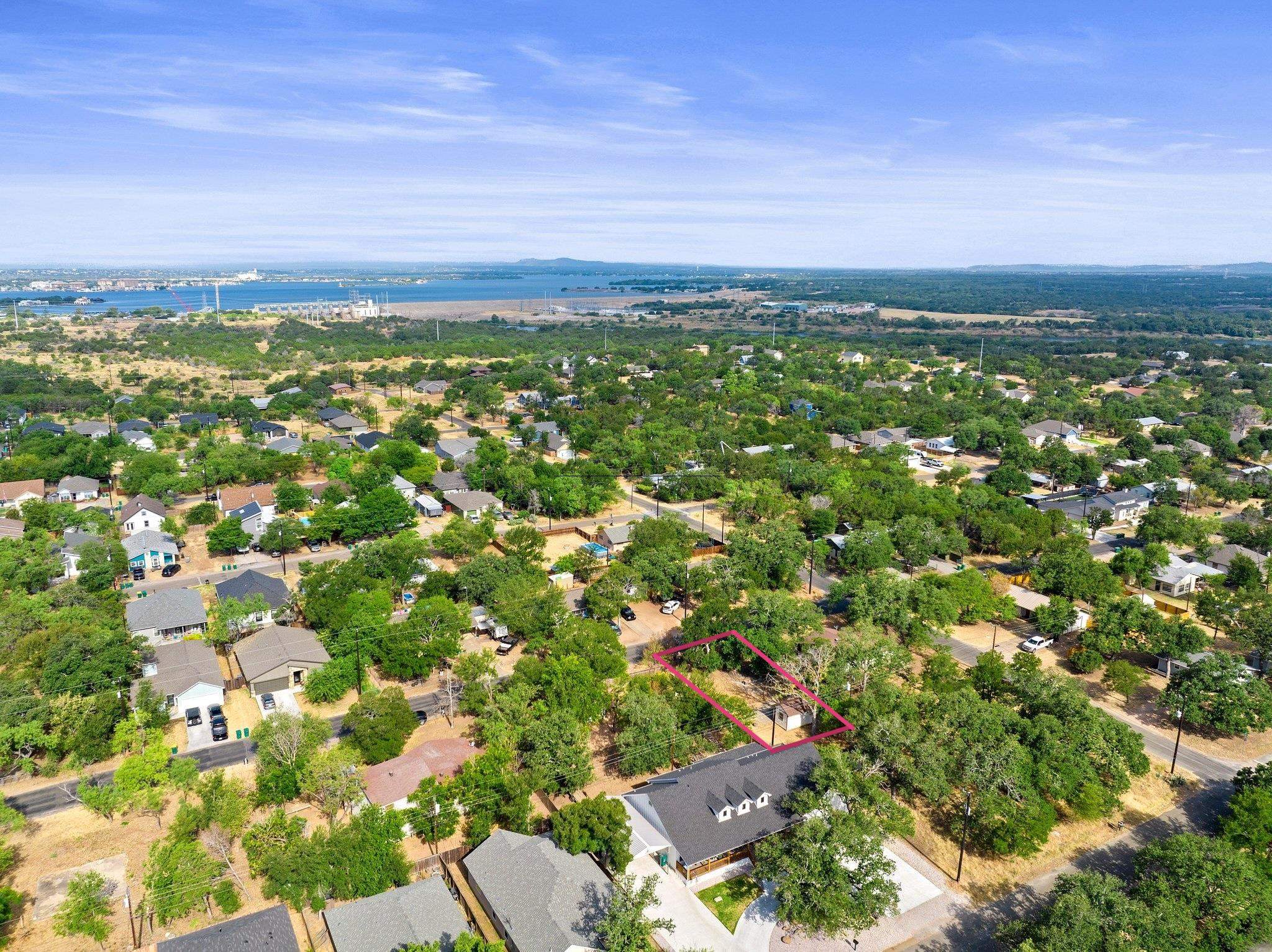 an aerial view of residential houses with outdoor space and trees