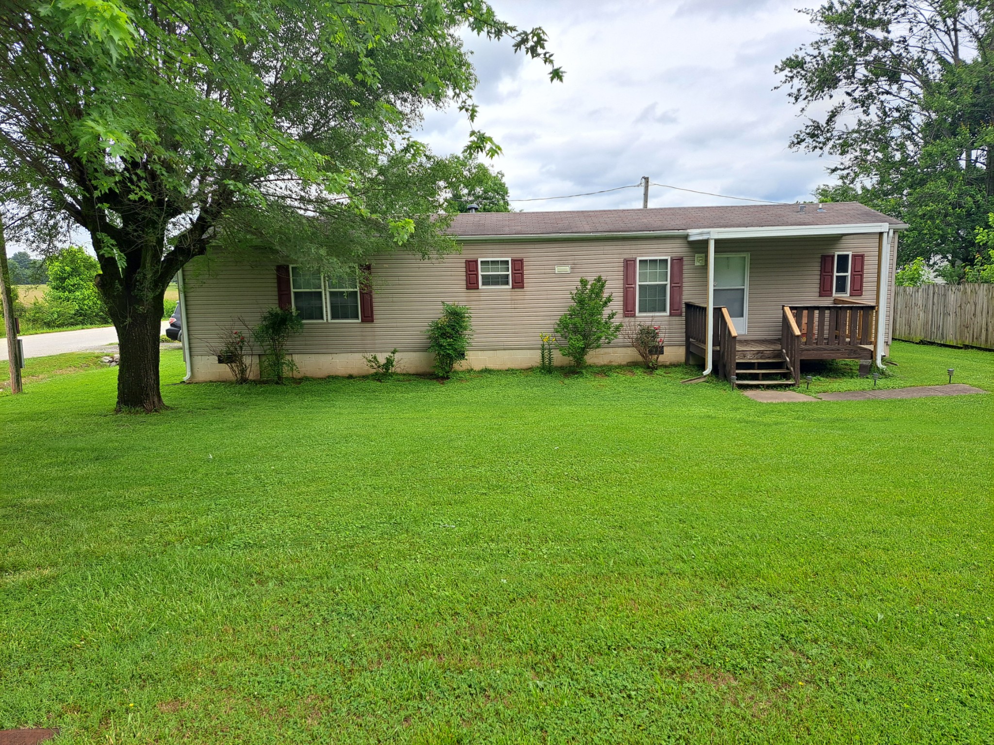 a front view of a house with a garden and trees