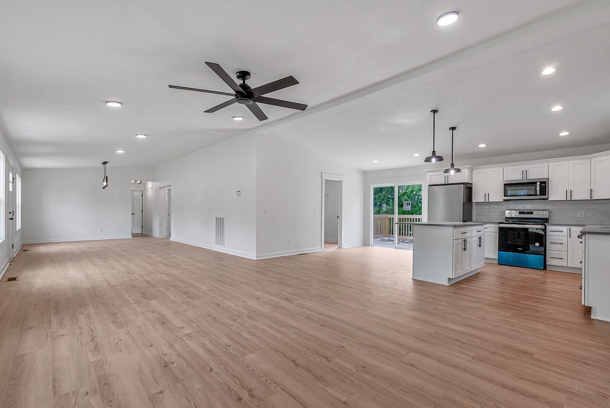 Large Open-Concept living space connecting the kitchen to the main family room and dining area.