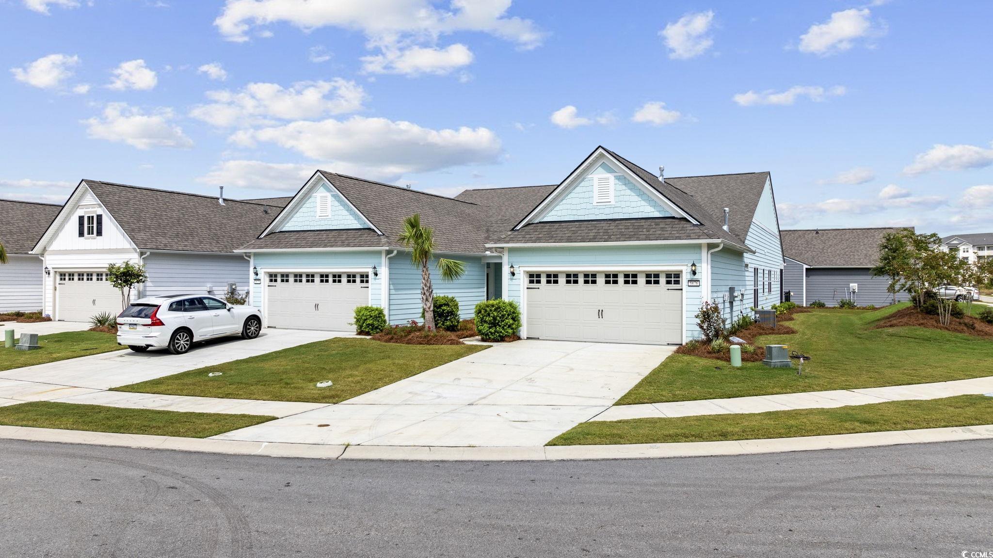 View of front of home with a front yard and a gara