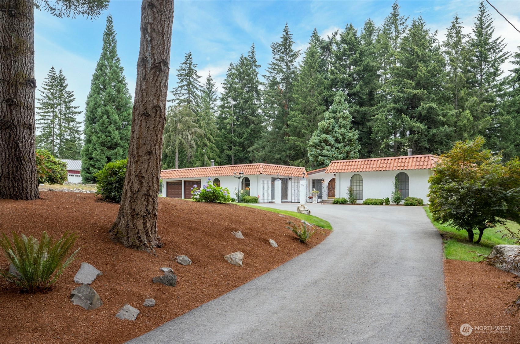 a front view of a house with a yard and trees