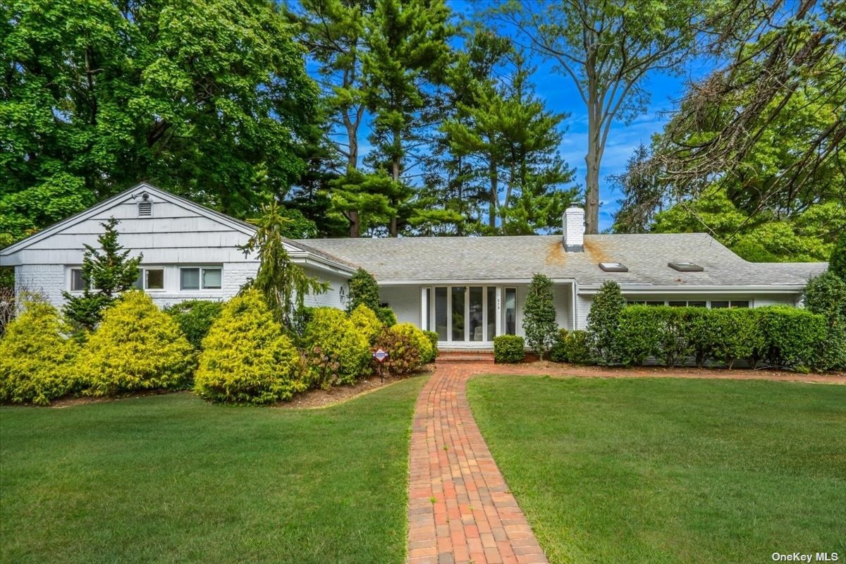 a front view of a house with a garden and plants