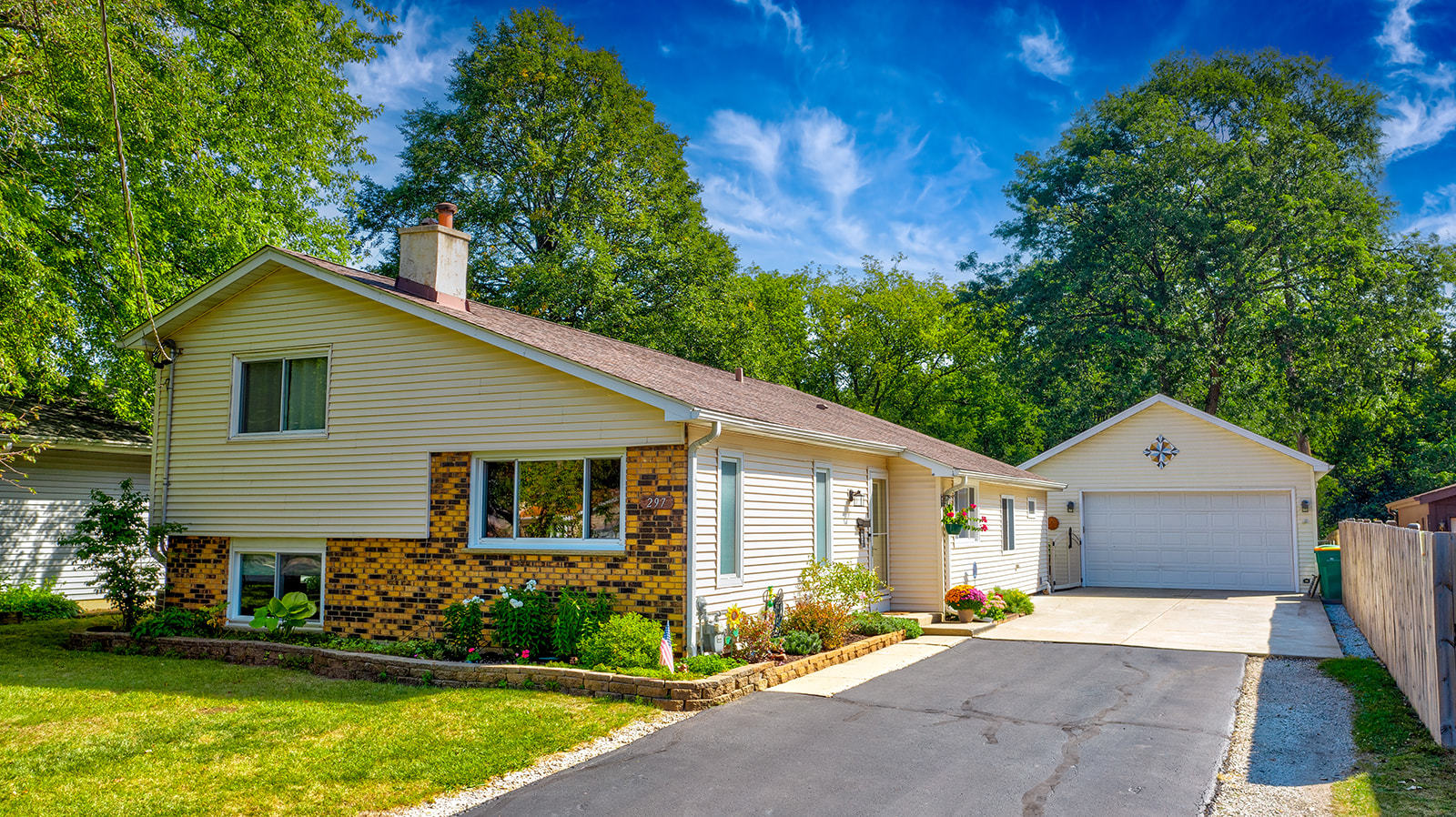 a front view of a house with a garden and yard