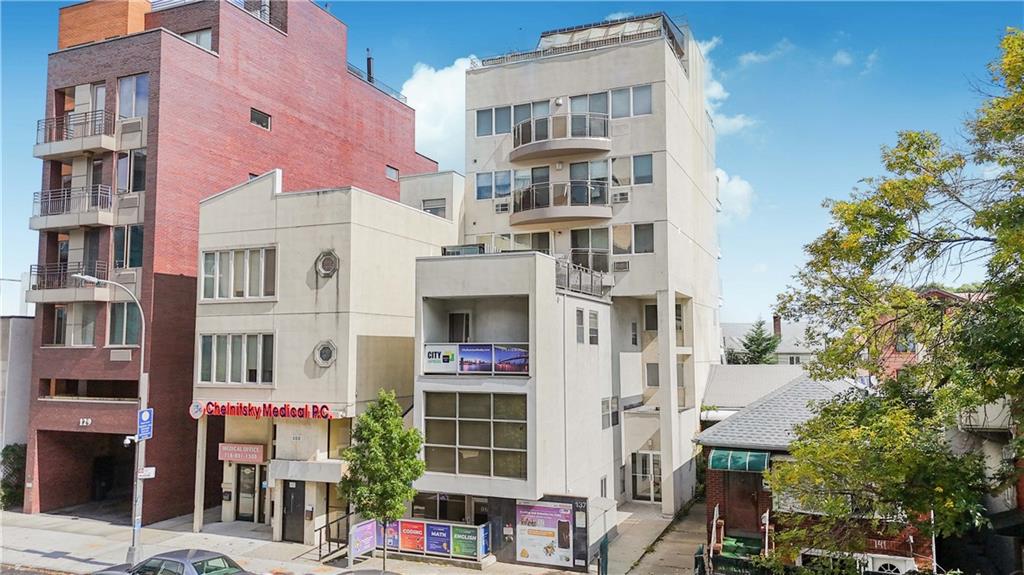 a front view of multi story residential apartment building with yard