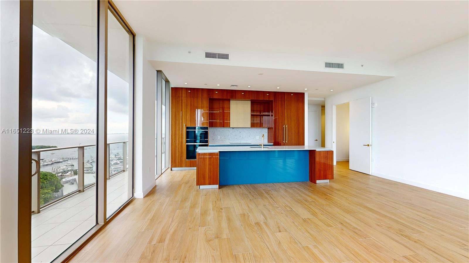 a kitchen with stainless steel appliances kitchen island a large counter top and a wooden floors