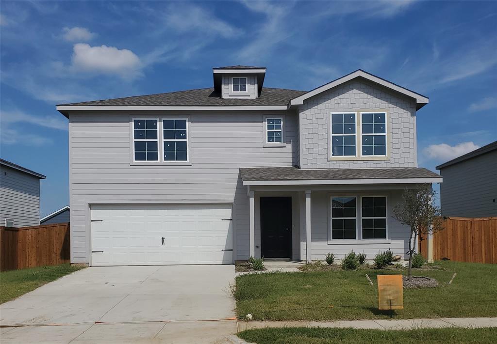 View of front of house featuring a front lawn and a garage