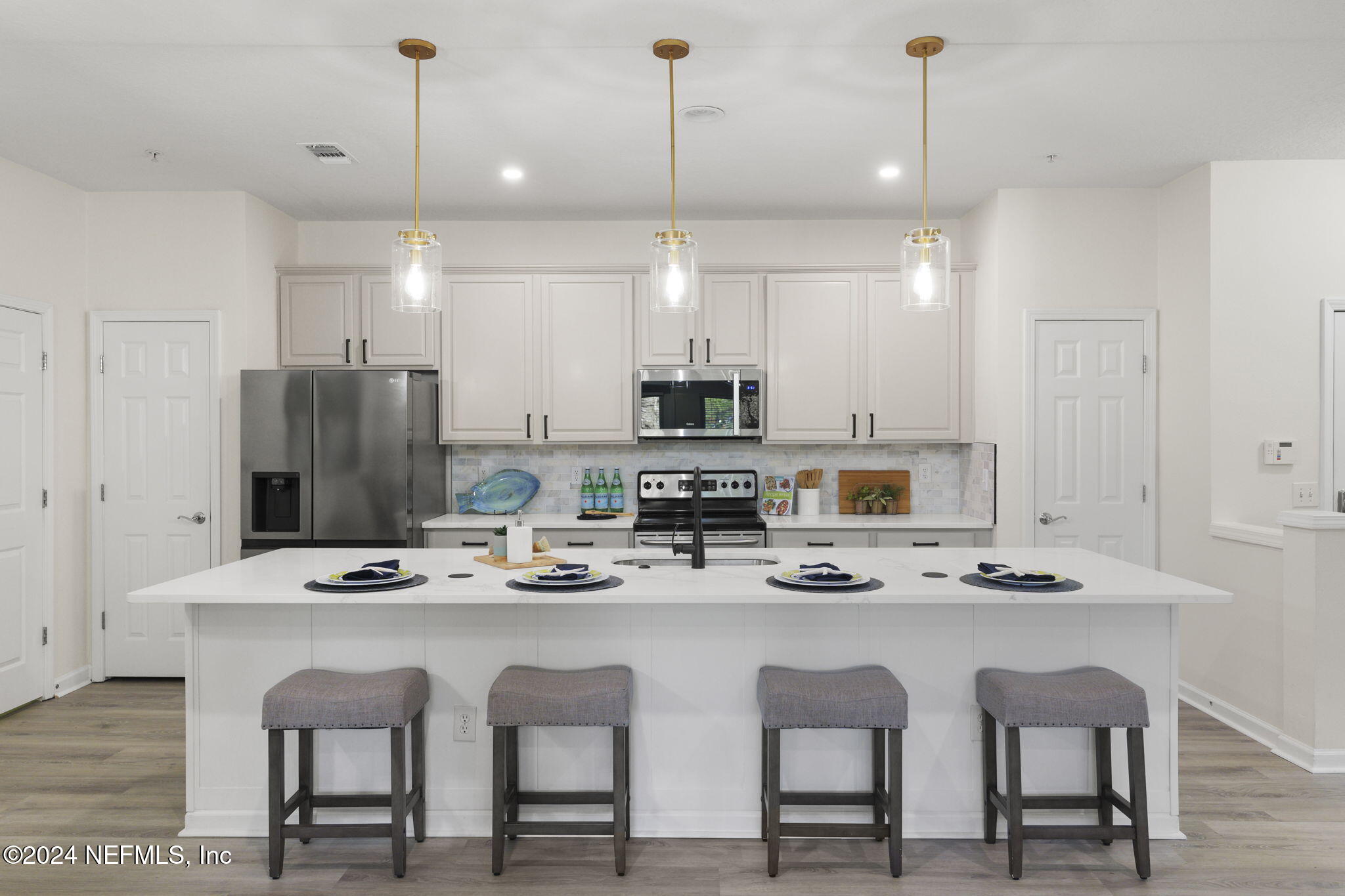 a kitchen with a dining table chairs refrigerator and microwave