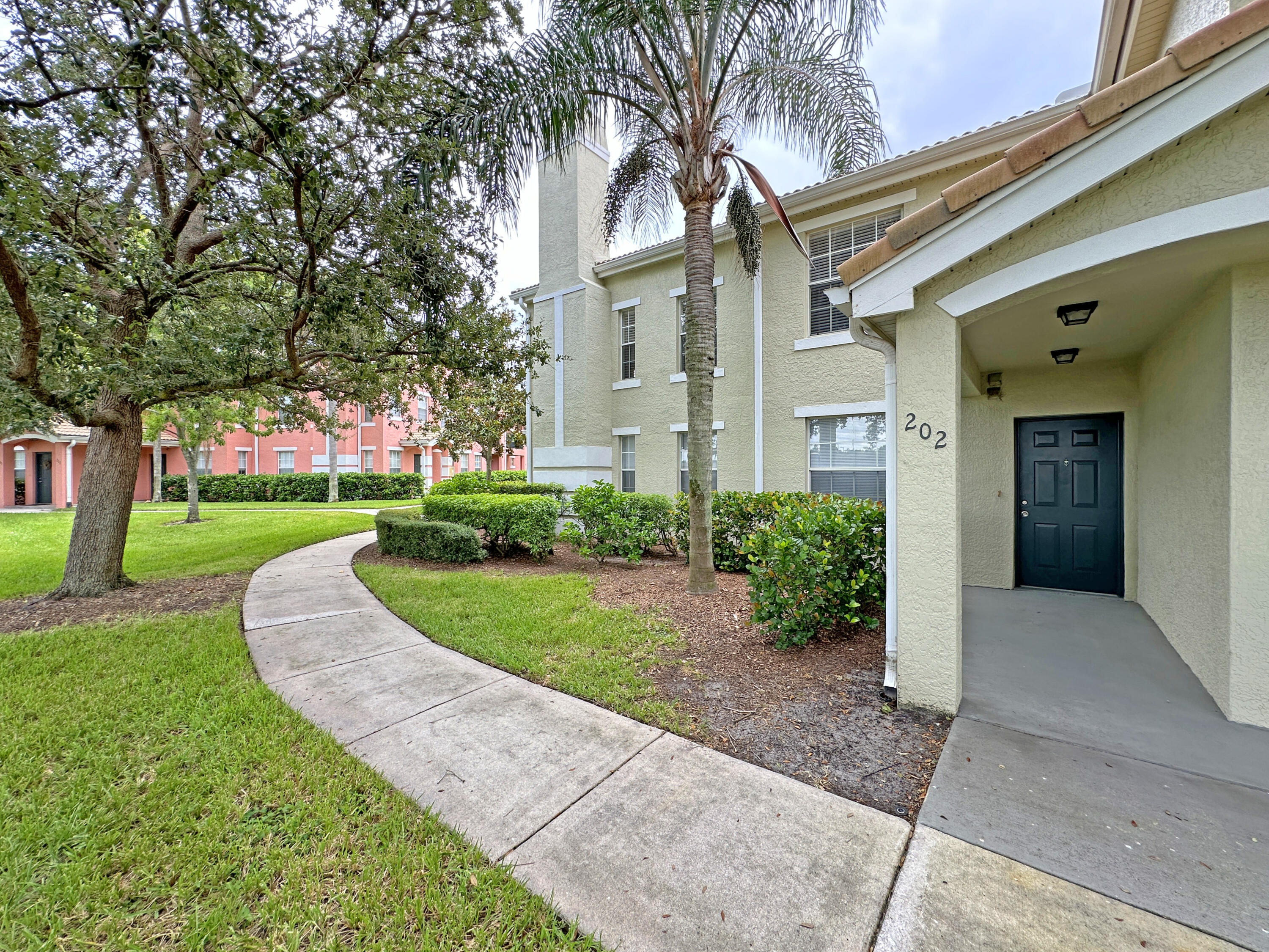 a front view of a house with a yard and potted plants