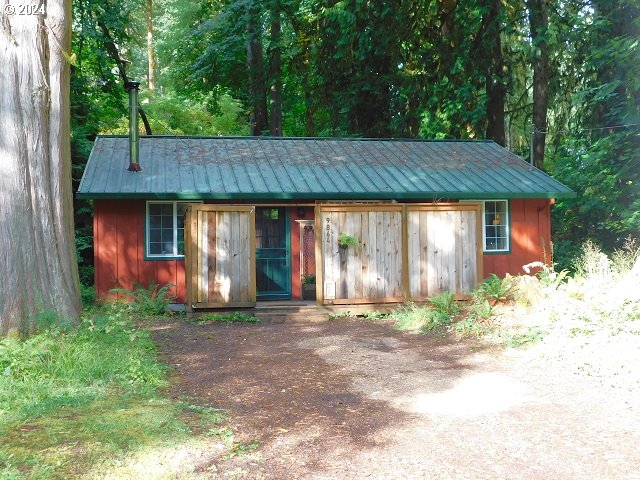 a backyard of a house with large trees and a barn