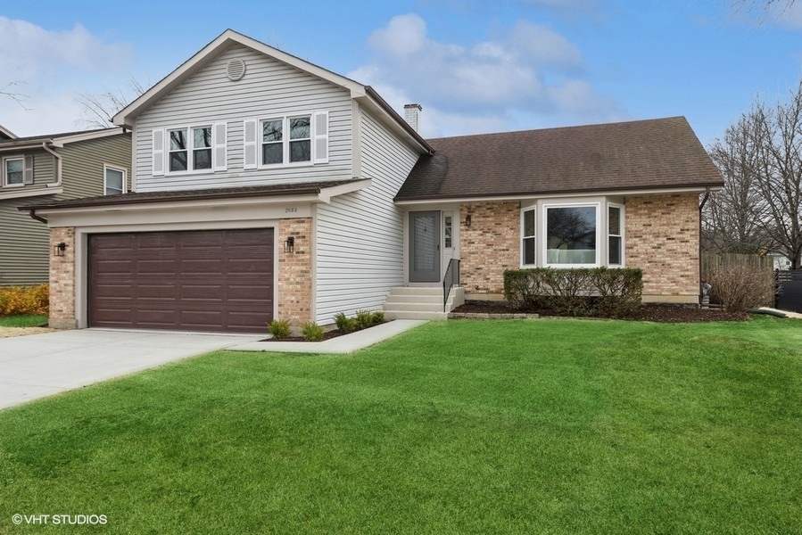 a front view of a house with a yard and garage