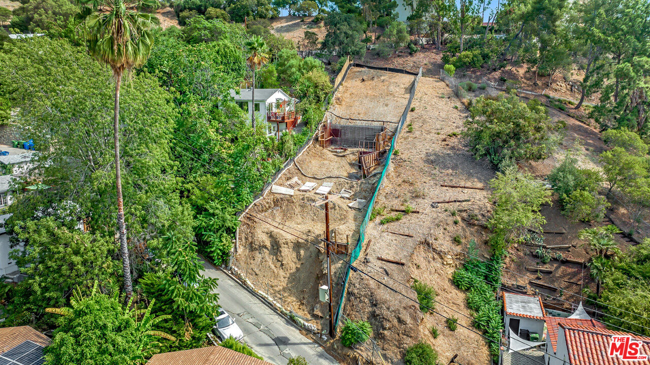 an aerial view of a house with a yard and large trees